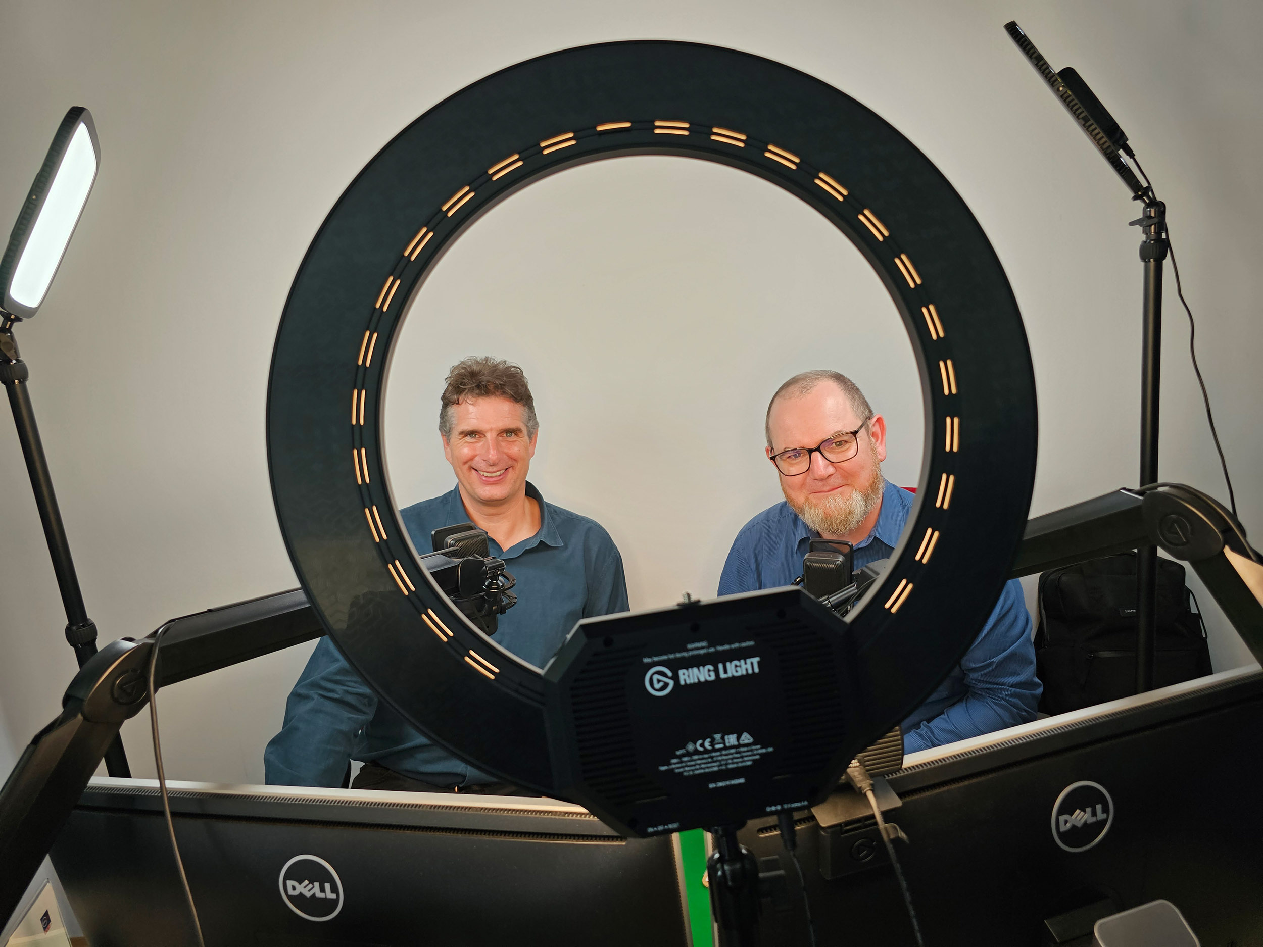 Gernot Winter und Christoph Tautscher nach der Aufnahme ihres 1,5h Videopodcasts. Beide schauen in einem Aufnahmestudio durch ein Ringlicht in die Kamera.